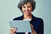 在平板电脑上工作的女人微笑着
